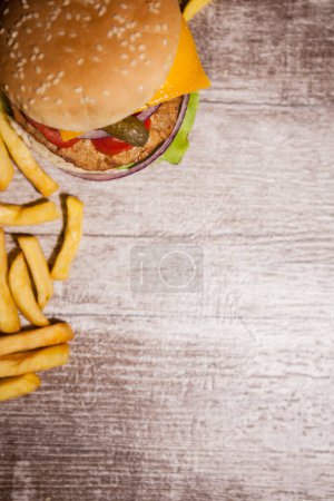 Téléchargez les photos : Hamburgers maison classiques sur une assiette en bois à côté des frites. Restauration rapide. Collation malsaine - en image libre de droit