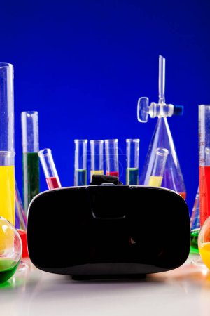 Foto de Laboratorio de química en una mesa con auriculares VR al lado. Equipos de cristalería y biología - Imagen libre de derechos