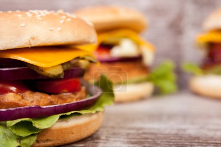 Téléchargez les photos : Gros plan de délicieux hamburgers faits maison sur une assiette en bois. Restauration rapide. Collation malsaine - en image libre de droit