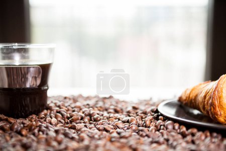 Téléchargez les photos : Café en grains, beignet et une tasse de café en gros plan photo - en image libre de droit