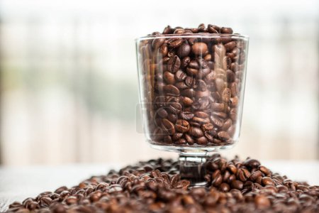 Photo for Glass Coffee cup on coffee beans in close up photo. Refreshing beverage in the morning - Royalty Free Image
