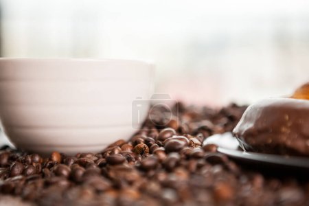 Photo for Coffee cup on coffee beans in close up photo. Refreshing beverage in the morning - Royalty Free Image