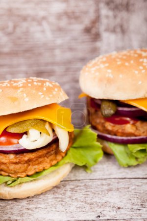 Téléchargez les photos : Délicieux hamburgers frais faits maison sur assiette en bois. Restauration rapide. Collation malsaine - en image libre de droit