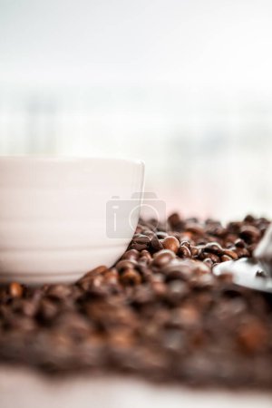Photo for Coffee cup on coffee beans in close up photo. Refreshing beverage in the morning - Royalty Free Image