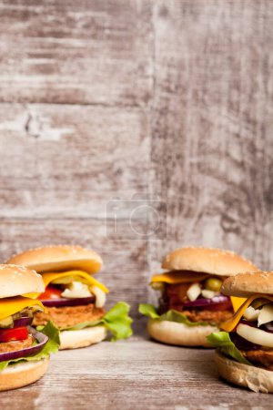 Téléchargez les photos : Délicieux hamburgers faits maison sur assiette en bois. Restauration rapide. Collation malsaine - en image libre de droit