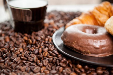 Photo for Croissant and coffee beans in close up photo. Delicious morning drink and snack - Royalty Free Image