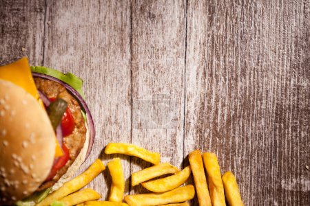 Photo for Delicious home made burgers on wooden plate next to fries. Fast food. Unhealthy snack - Royalty Free Image