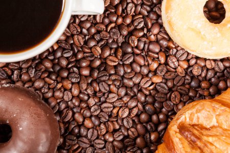 Foto de Vista superior de granos de café, donut y una taza de café en la foto de cerca - Imagen libre de derechos