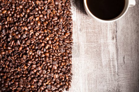 Foto de Taza de café en granos de café en la foto de cerca. Bebida refrescante por la mañana - Imagen libre de derechos