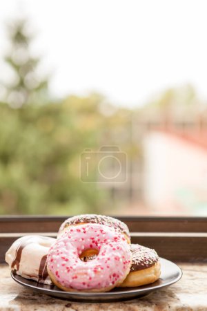 Téléchargez les photos : Assiette avec beignets à côté du rebord de la fenêtre. Délicieux junck food - en image libre de droit