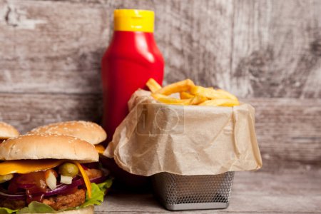 Photo for Home made gourmet burgers on wooden plate next to fries. Fast food. Unhealthy snack - Royalty Free Image