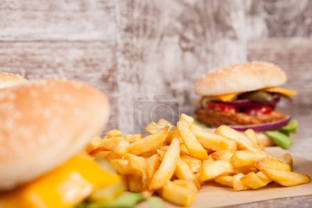 Photo for Tasty home made burgers on wooden plate next to fries. Fast food. Unhealthy snack - Royalty Free Image