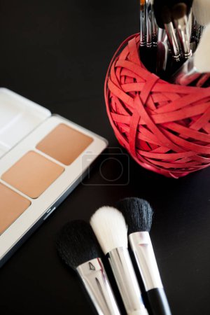Foto de Maquillaje y productos cosméticos sobre fondo negro. Cosméticos profesionales - Imagen libre de derechos