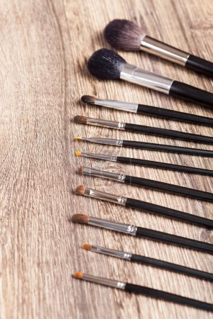 Téléchargez les photos : Professional make-up brushes on wooden background. Beauty industry - en image libre de droit