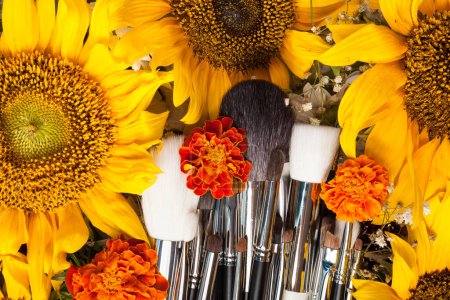 Téléchargez les photos : Brosses de maquillage à côté de belles fleurs sauvages sur fond en bois - en image libre de droit