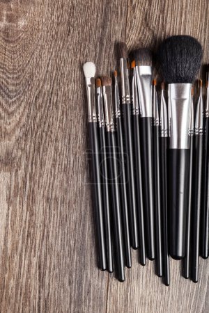 Foto de Professional make-up brushes on wooden background. Beauty industry - Imagen libre de derechos