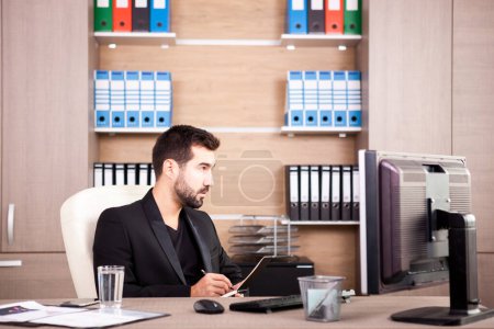 Téléchargez les photos : Jeune homme d'affaires fatigué travaillant dans son bureau. Homme d'affaires dans un environnement professionnel - en image libre de droit