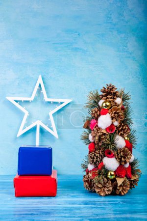 Téléchargez les photos : Mini sapin de Noël sur fond bleu en photo studio. Saisonnière and holiday - en image libre de droit