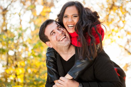 Téléchargez les photos : Incroyable drôle jeune couple dans automne parc avoir amusant - en image libre de droit