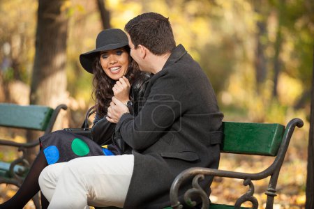 Foto de Hermosa pareja sentada en un banco en el parque de otoño - Imagen libre de derechos