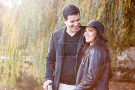 Foto de En pareja enamorada caminando en el parque de otoño cerca de un lago - Imagen libre de derechos