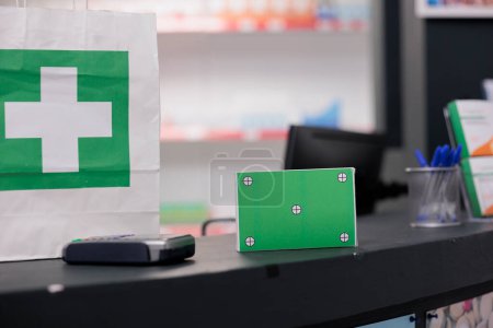 Foto de Green screen mock up chroma key pills packages standing on drugstore counter desk in empty pharmacy. Health care store filled with pharmaceutical products and medicaments bottles, medicine concept - Imagen libre de derechos