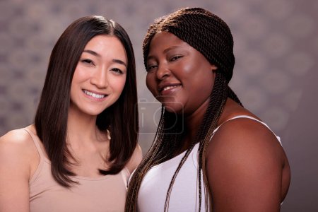 Photo for Diverse smiling cheerful beauty models looking at camera with positive emotions. Beautiful african american and asian young women with different body shapes and ethnicity posing together close up - Royalty Free Image