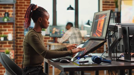 Foto de African american woman designing game interface on computer with touchscreen display, working on 3d project development. Female editor using artificial intelligence for digital content. - Imagen libre de derechos