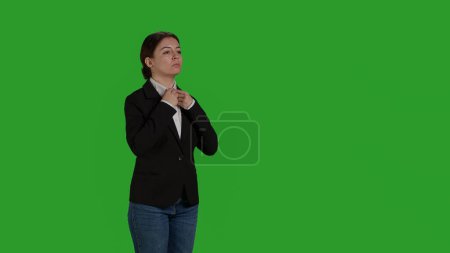 Photo for Side view of businesswoman standing on green screen backdrop, feeling confident in corporate office suit. Smiling worker posing on camera and feeling optimistic in studio, positive formal person. - Royalty Free Image