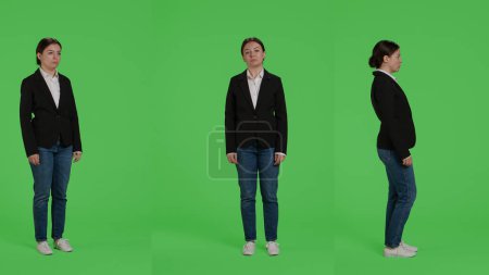 Téléchargez les photos : Plein corps écran vert toile de fond de femme d'affaires, posant sur la caméra. Employée de bureau en costume debout sur fond vert, confiante et optimiste travailleur de l'entreprise. - en image libre de droit