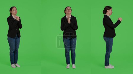 Photo for Spiritual woman with corporate job doing prayer hands over bull body greenscreen backdrop, expressing belief and begging to god. Businesswoman praying and acting religious in studio. - Royalty Free Image