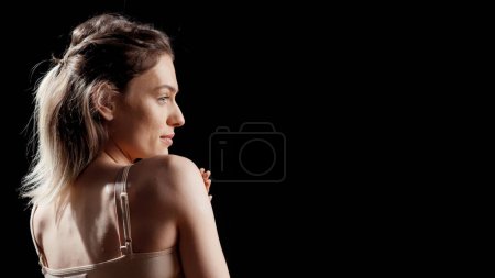 Photo for Confident woman applying moisturizing cream on body, enjoying beauty skincare routine on camera. Young cheerful person promoting bodycare and self confidence, empowering campaign. - Royalty Free Image