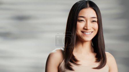 Photo for Young flawless woman promoting skincare ad on camera, lady with radiant glowing skin feeling confident. Beautiful smiling girl creating empowering, uplifting bodycare campaign. - Royalty Free Image