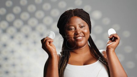 Photo for Skincare model posing with cotton pads on face in studio, using toner and cleansing products to have glowing skin. Confident woman being glamorous and radiant, nourishing bodycare. - Royalty Free Image