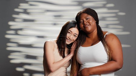Téléchargez les photos : Diverse models feeling powerful posing for beauty ad, having natural luminous skin and promoting self confident. Beautiful women smiling and expressing self love and femininity. - en image libre de droit