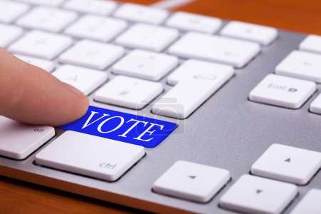 Photo for Finger pressing on vote blue button on keyboard. Online elections - Royalty Free Image
