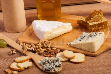 Téléchargez les photos : Dor bleu et blanc fromage aux noix et miel sur fond bois vintage en studio photo - en image libre de droit