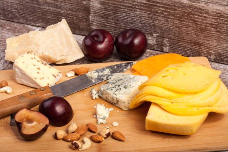 Téléchargez les photos : Noix, fromage et fruits sur fond bois en studio photo - en image libre de droit
