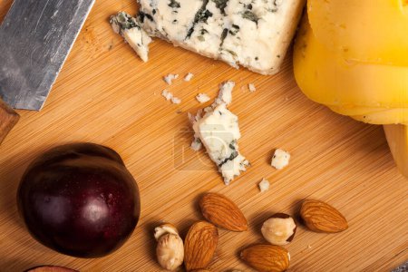Téléchargez les photos : Noix, fromage et fruits sur fond bois en studio photo - en image libre de droit