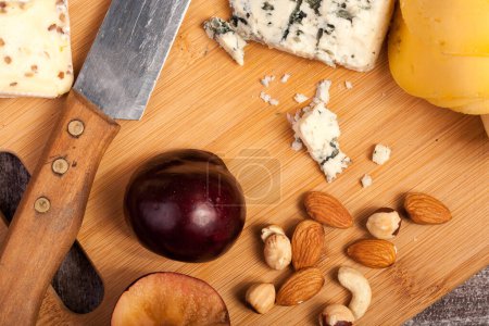 Photo for Cheese, nuts and fruits on wooden background in studio photo - Royalty Free Image