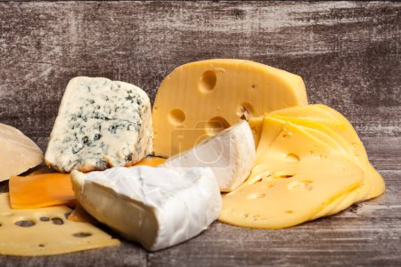 Téléchargez les photos : Différents types de fromage sur fond en bois. Apéritif alimentaire gastronomique - en image libre de droit