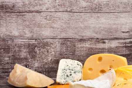 Téléchargez les photos : Différents types de fromage sur fond en bois. Apéritif alimentaire gastronomique - en image libre de droit