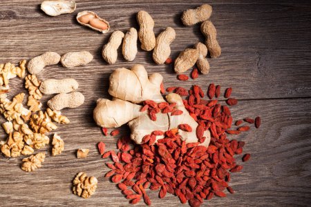 Photo for Raw organic food and nuts on wooden background. Over top view - Royalty Free Image
