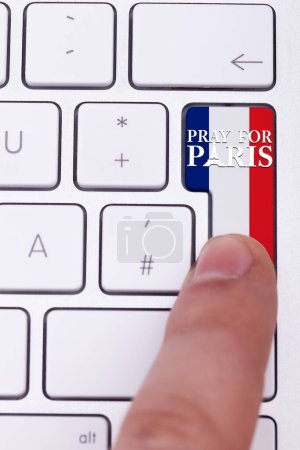 Photo for Pressing pray for Paris sign on key with France flag. Terrorist attack against France. International suport for terrorist victims in Paris atack - Royalty Free Image