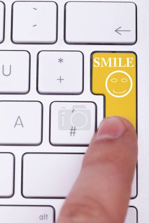 Foto de Pulsando el dedo botón sonrisa en el teclado con un signo de sonrisa en él - Imagen libre de derechos