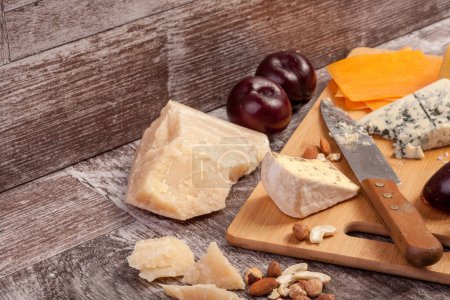 Foto de Diferentes tipos de queso y nueces sobre fondo de madera vintage en foto de estudio - Imagen libre de derechos