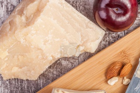Photo for Over type view of fruits, cheese and nuts on wooden background. - Royalty Free Image