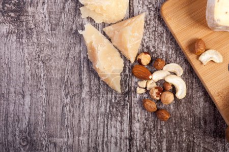 Photo for Healthy food. Nuts and cheese on wooden background - Royalty Free Image