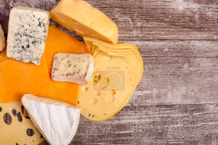 Téléchargez les photos : Différents types de fromage cher, noix et miel sur fond en bois - en image libre de droit
