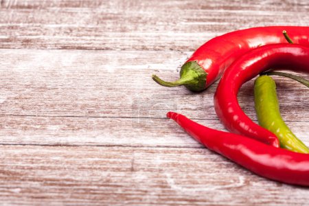 Photo for Spicy Red and green pepper on wooden background in studio photo - Royalty Free Image